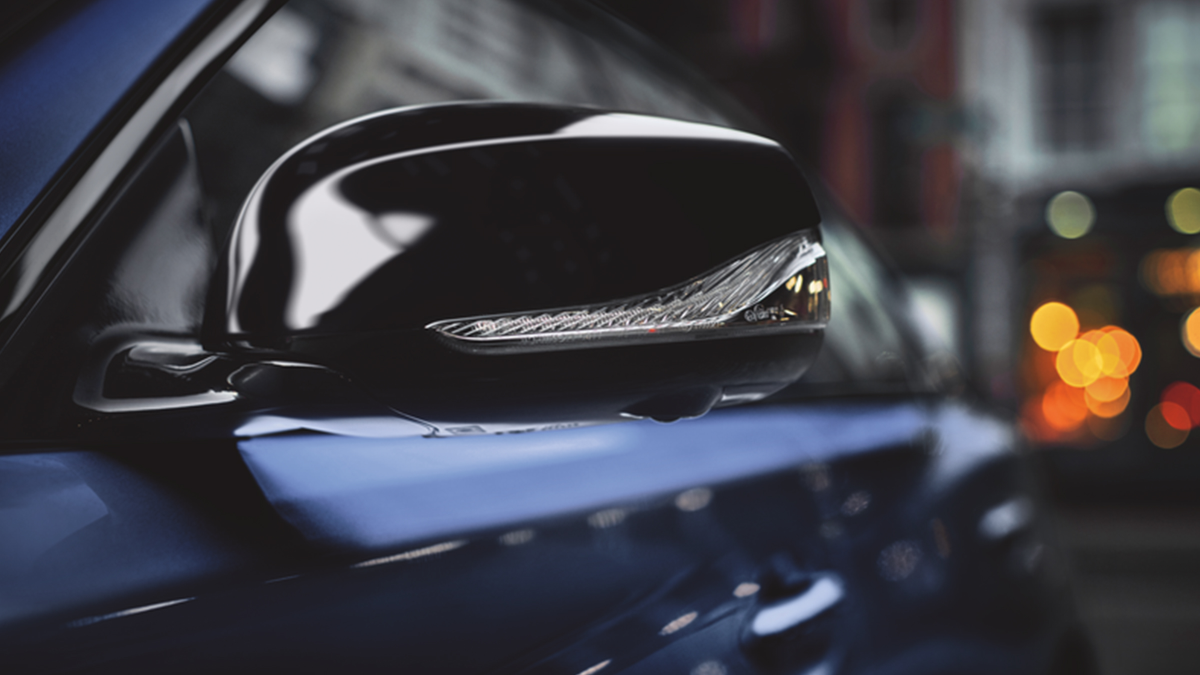 A close-up of the 2022 INFINITI Q50 blue sedan's side-view mirror.