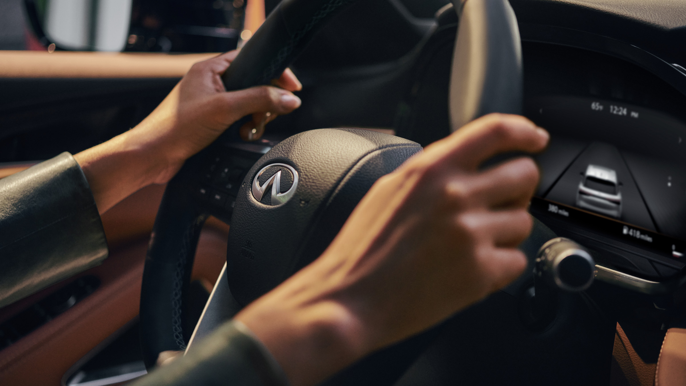 2022 INFINITI black steering wheel with two hands driving it.
