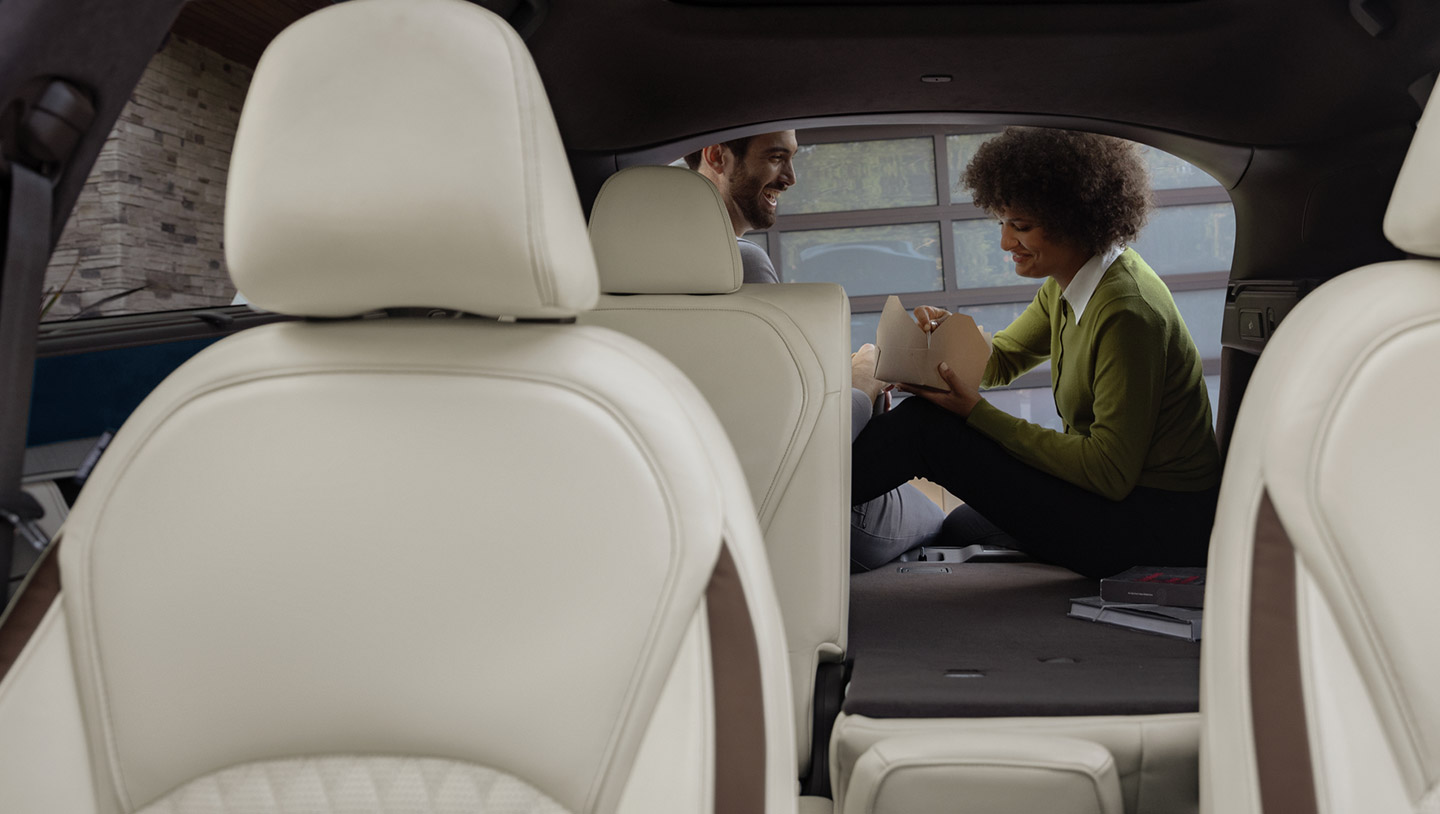 Name here: A couple eating in the cargo space of the 2024 INFINITI QX50 compact SUV