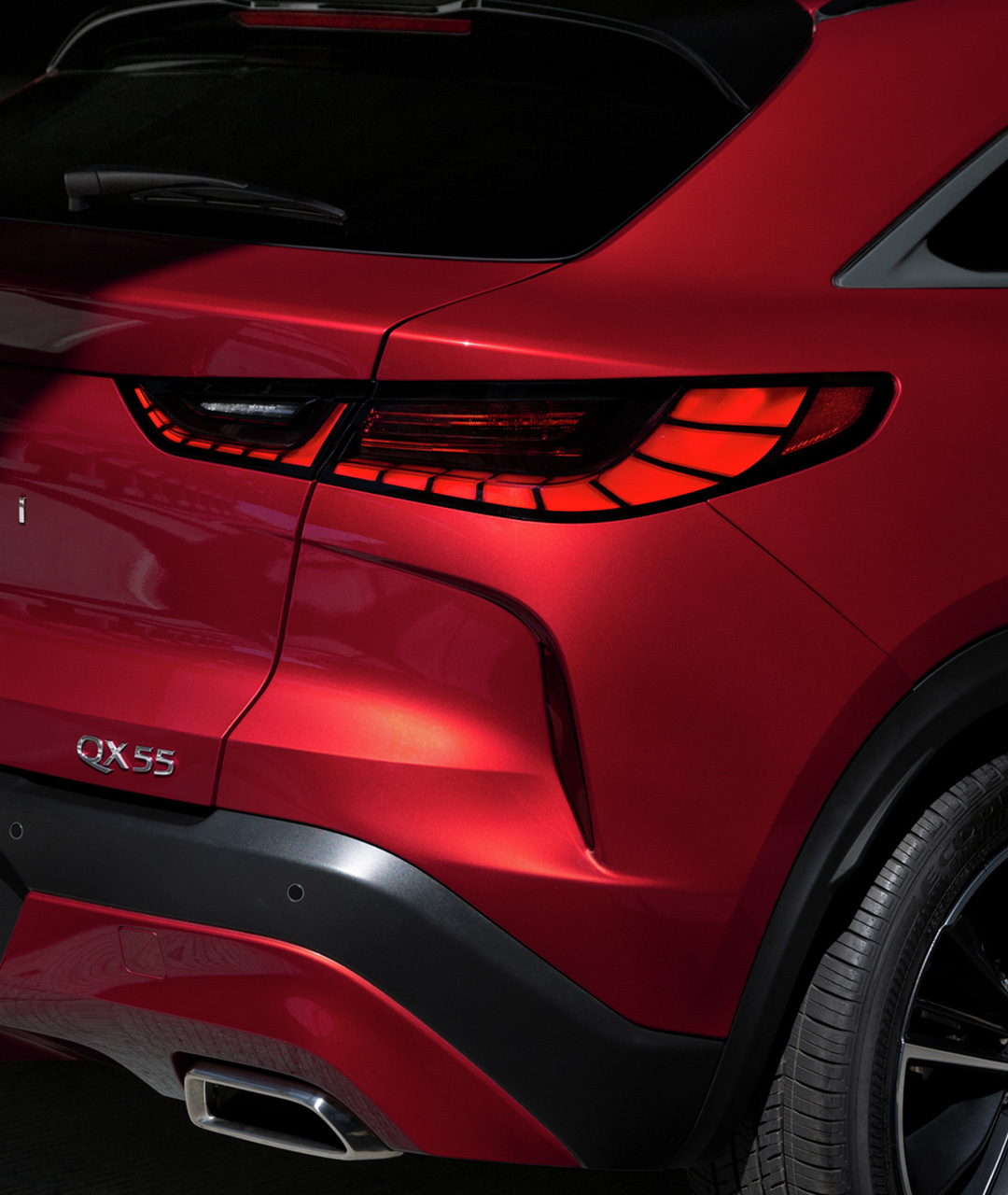Close-up view of a red 2024 INFINITI QX55 crossover coupe with piano key LED tail lights
