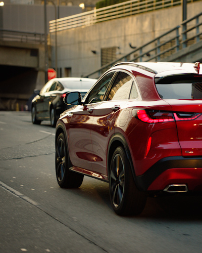 Angled back view of a red 2024 INFINITI QX55 crossover coupe with ProPilot Assist