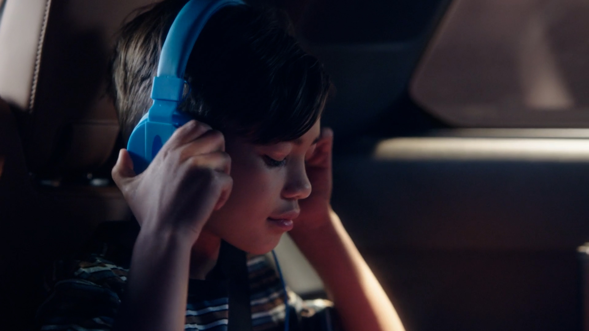 Girl listening with headphones in the 2023 INFINITI QX60 Crossover SUV 