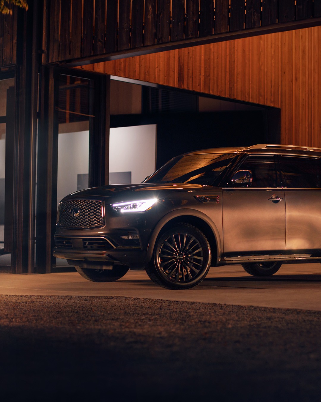 A black 2024 INFINITI QX80 SUV parked at night