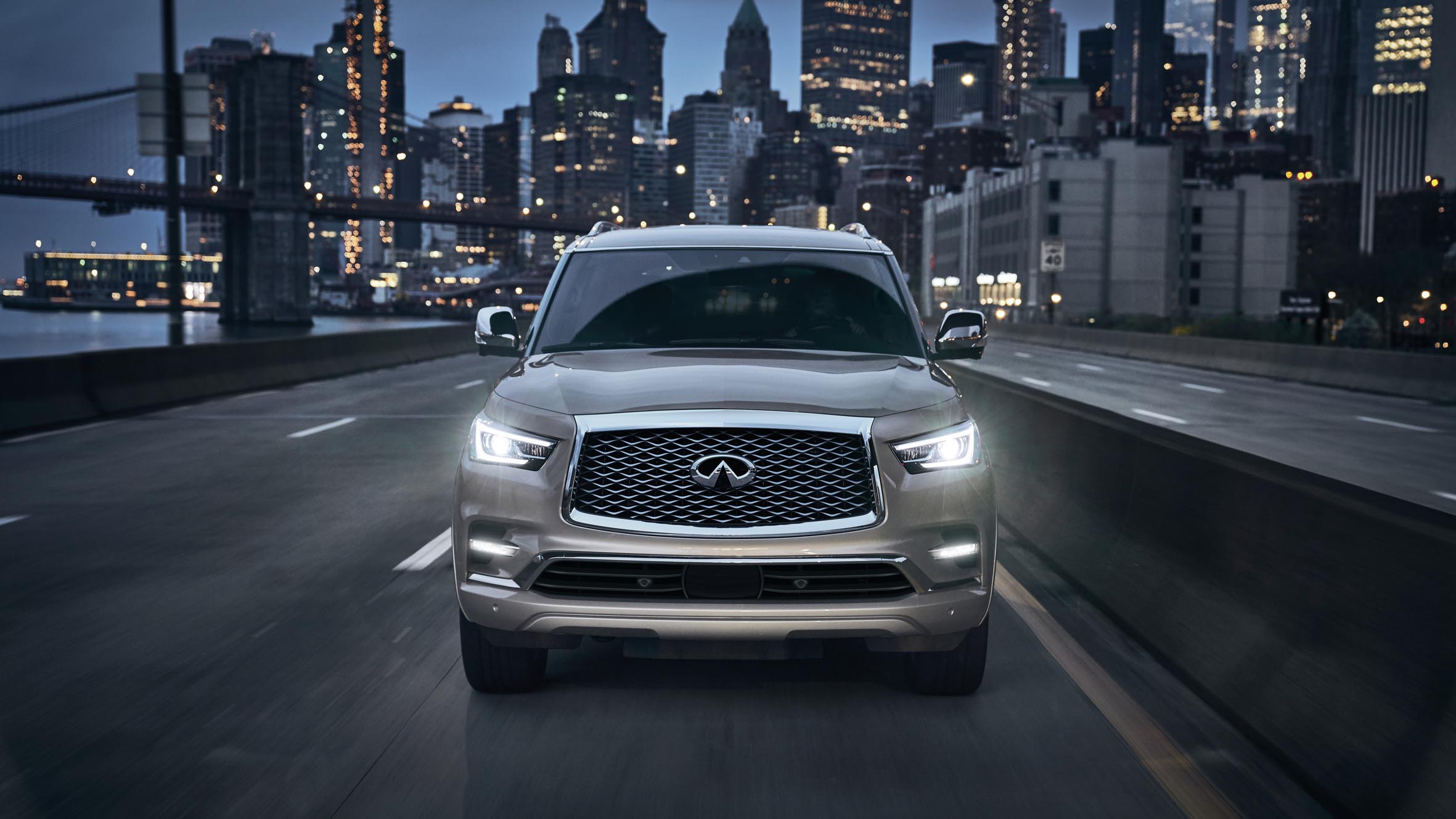 Front-view of a 2022 INFINITI QX80 driving through the city.