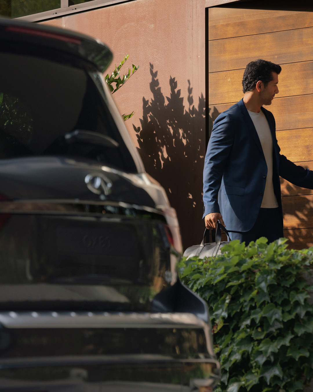 Owner next to a dark grey 2024 INFINITI QX80 7-8 seater SUV
